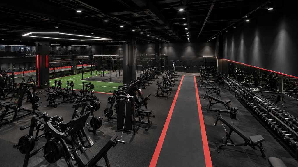 Large commercial gym divided into strength free weight and functional training zones